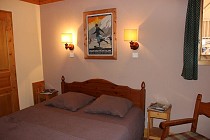 Chalet Selaou - slaapkamer met schilderij en 2-persoonsbed